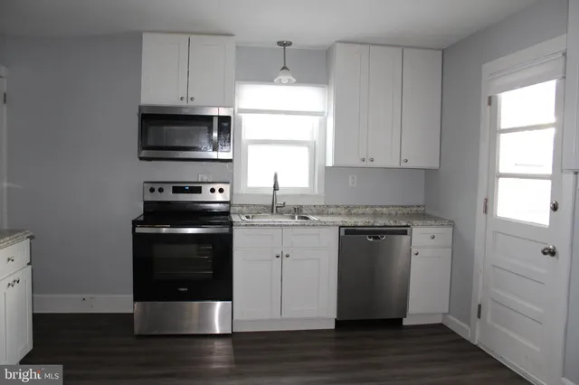 a kitchen with stainless steel appliances granite countertop a stove a microwave and a refrigerator