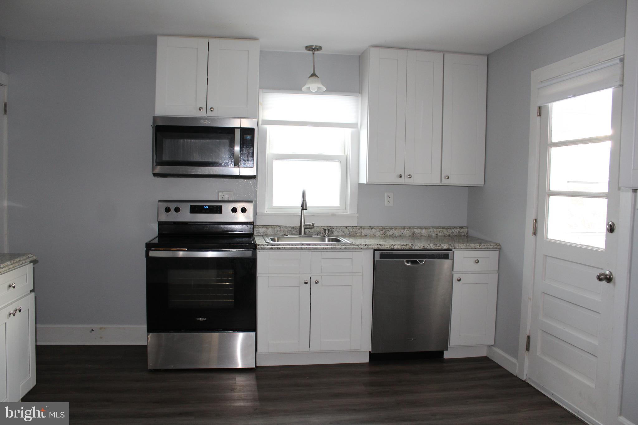 4529 Devonshire Road Harrisburg, PA 17109 - Photo 2 of 22 a kitchen with stainless steel appliances granite countertop a stove a microwave and a refrigerator