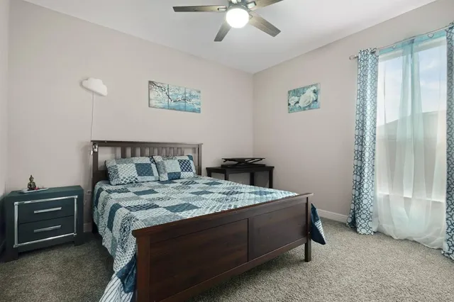 a living room with furniture gym equipment and a ceiling fan