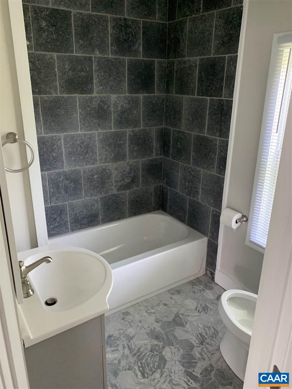 1109 Myrtle Street, Unit B Charlottesville, VA 22902 - Photo 8 of 14 a white bath tub sitting next to a white toilet