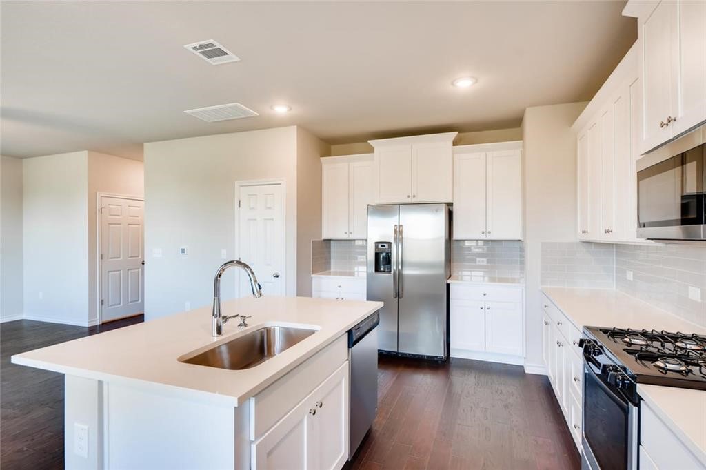 11608 Roxburgh Pass Austin, TX 78754 - Photo 4 of 12 a kitchen with refrigerator a sink and cabinets