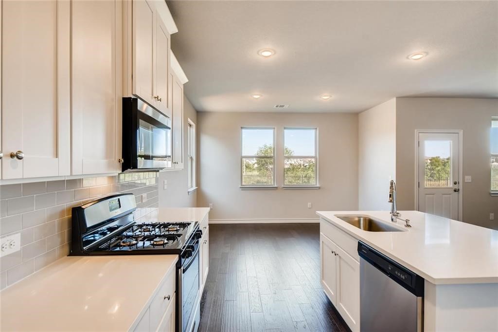 11608 Roxburgh Pass Austin, TX 78754 - Photo 5 of 12 a kitchen with stainless steel appliances a sink stove and wooden floor