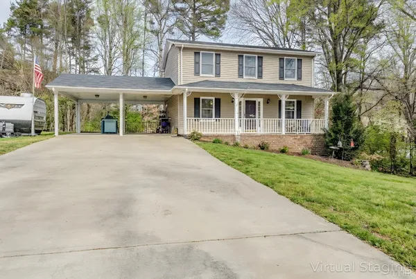 a view of a house with backyard and a tree