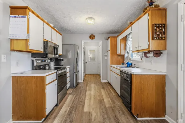 a large kitchen with stainless steel appliances granite countertop a stove a sink dishwasher and a refrigerator