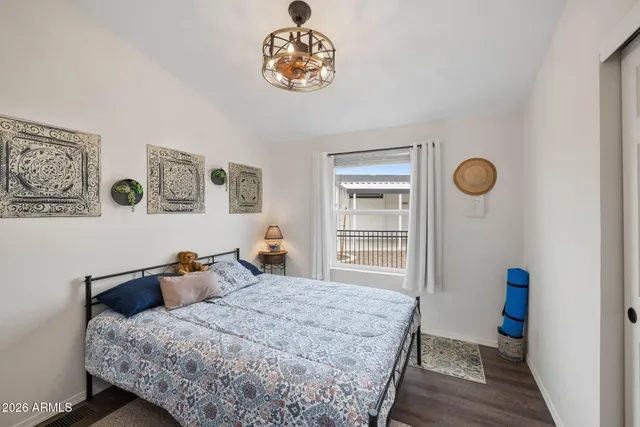 a bedroom with bed and wooden floor