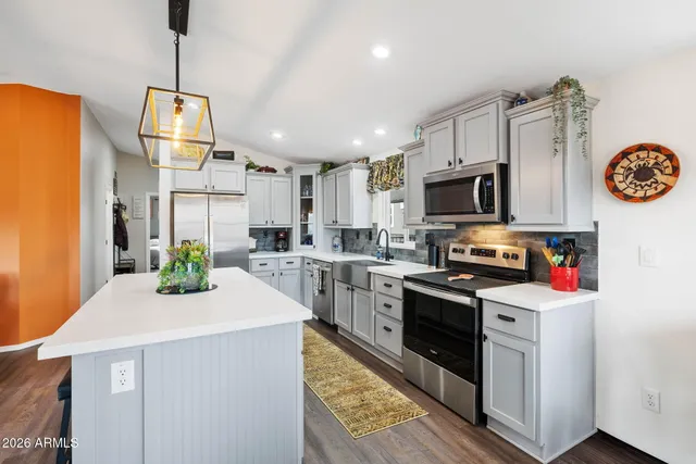 a kitchen with a sink a stove top oven and white cabinets