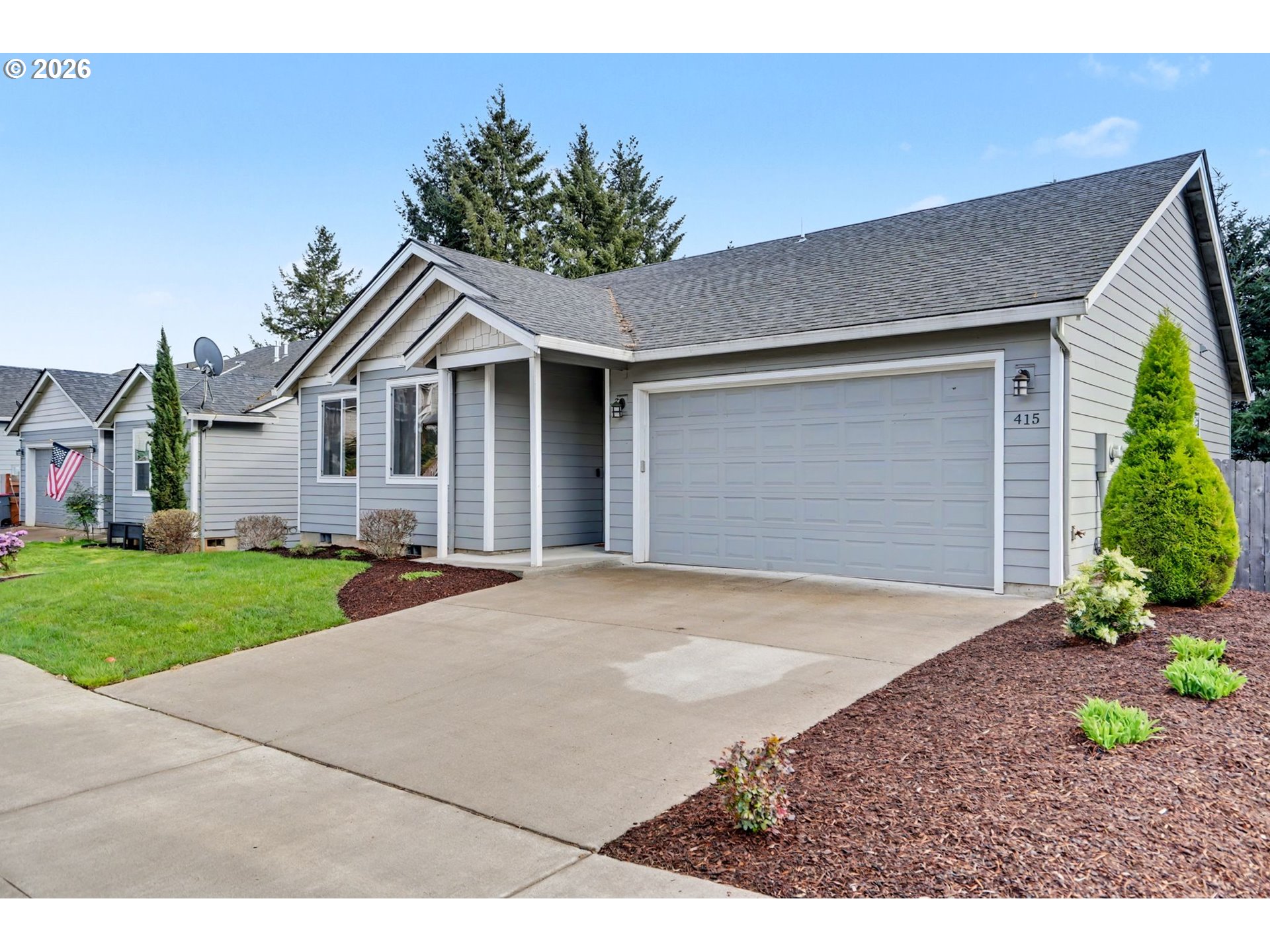 415 Northwest 6th Street Willamina, OR 97396 - Photo 2 of 34 a front view of a house with a yard and garage