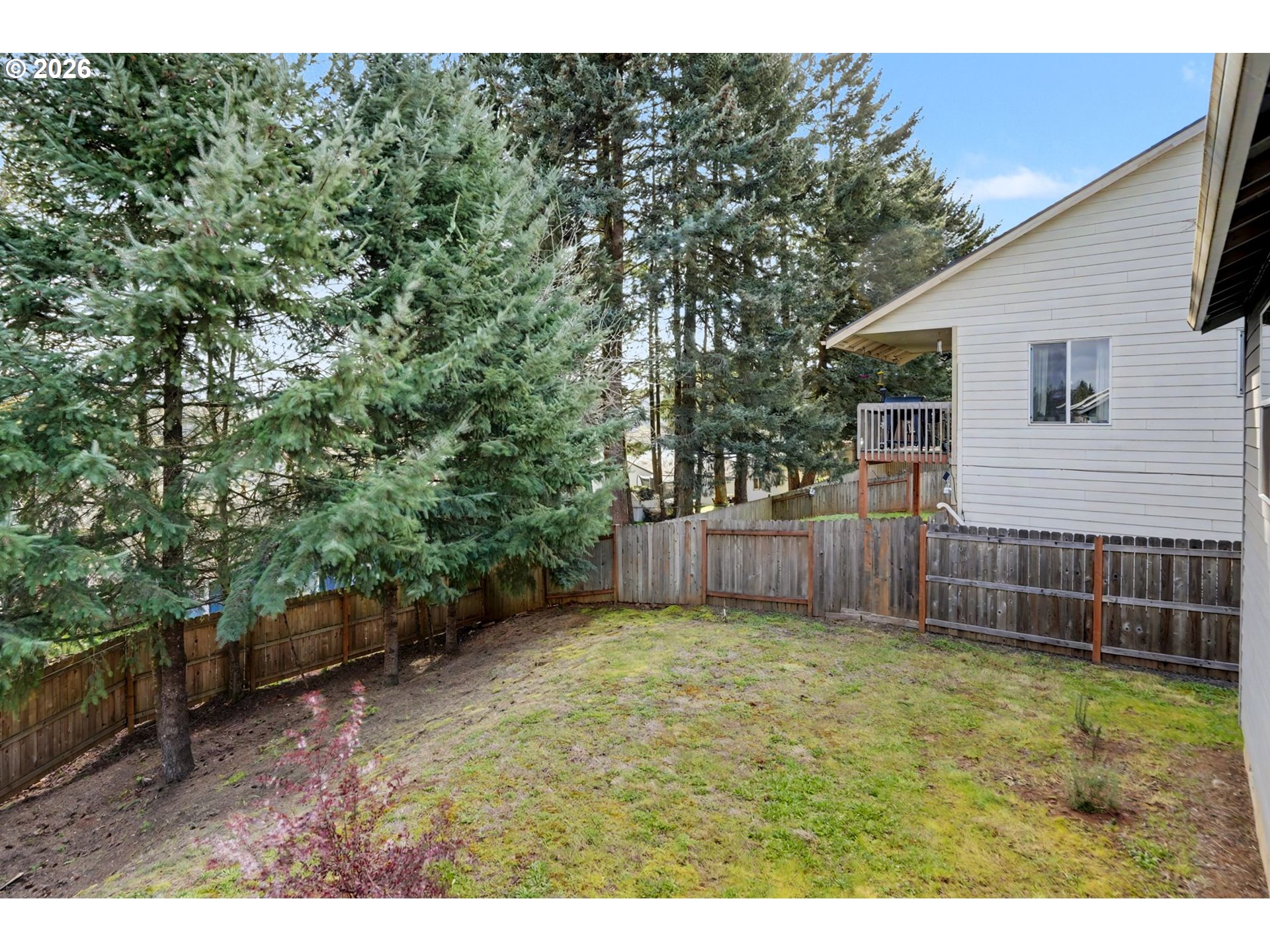 415 Northwest 6th Street Willamina, OR 97396 - Photo 29 of 34 a view of a backyard with a large tree and wooden fence
