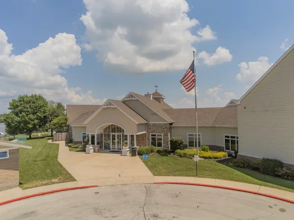 an aerial view of ocean and residential houses with outdoor space