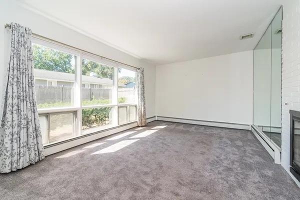 an empty room with fireplace and windows