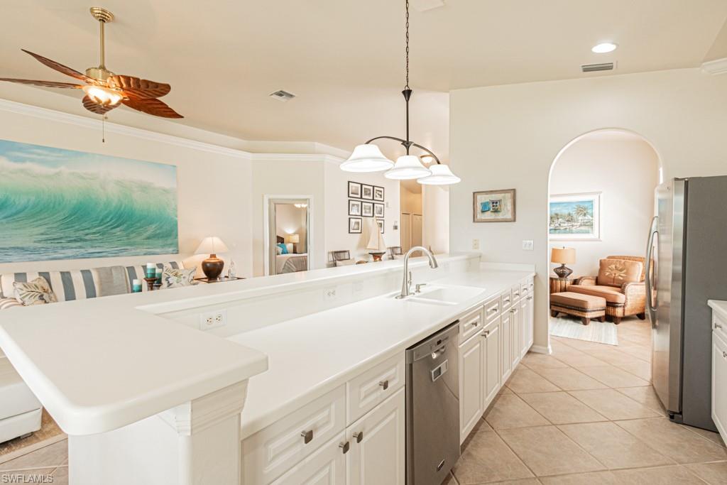 1965 Crestview Way, Unit 156 Naples, FL 34119 - Photo 12 of 45 a large white kitchen with a large island oven a stove and a chandelier