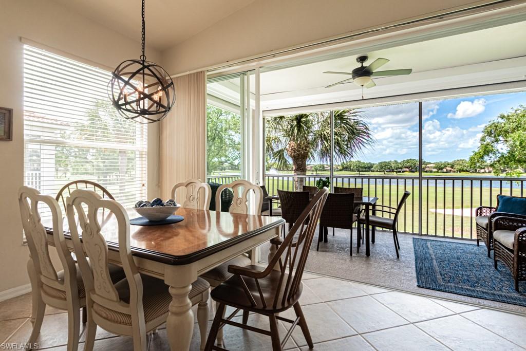1965 Crestview Way, Unit 156 Naples, FL 34119 - Photo 14 of 45 a dining room with furniture a chandelier and wooden floor