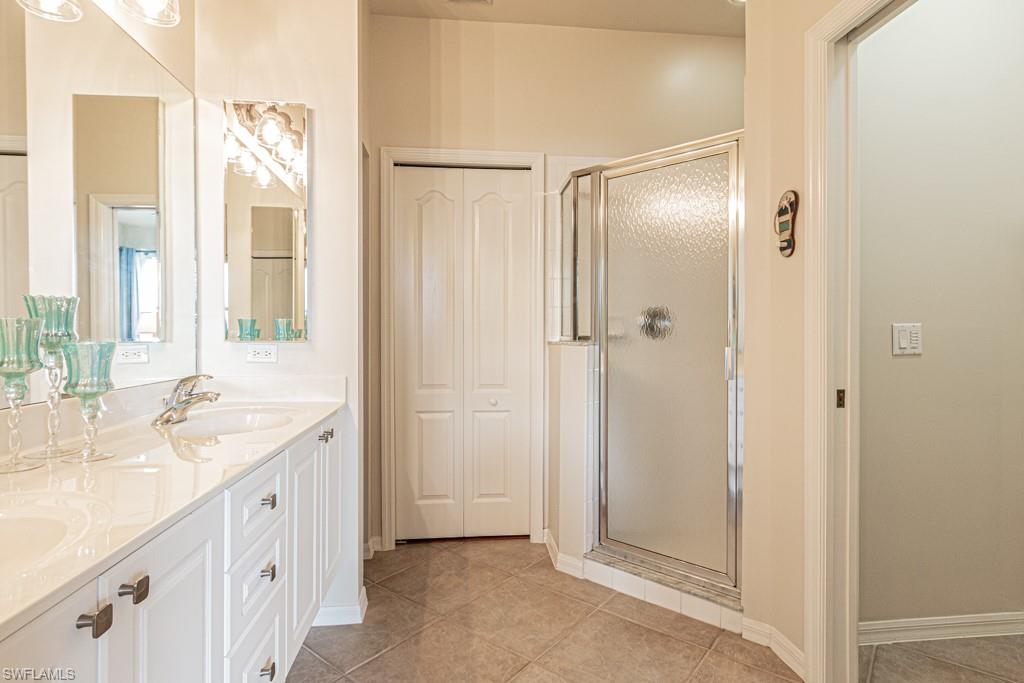 1965 Crestview Way, Unit 156 Naples, FL 34119 - Photo 17 of 45 a bathroom with a double vanity sink a mirror and a shower