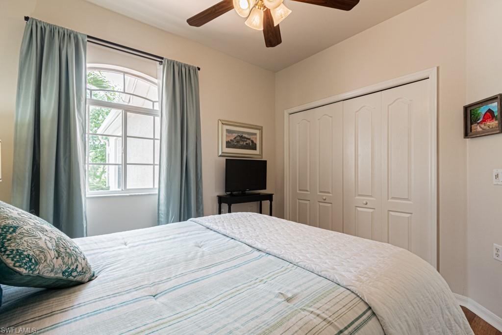 1965 Crestview Way, Unit 156 Naples, FL 34119 - Photo 21 of 45 a bedroom with a bed and a chandelier