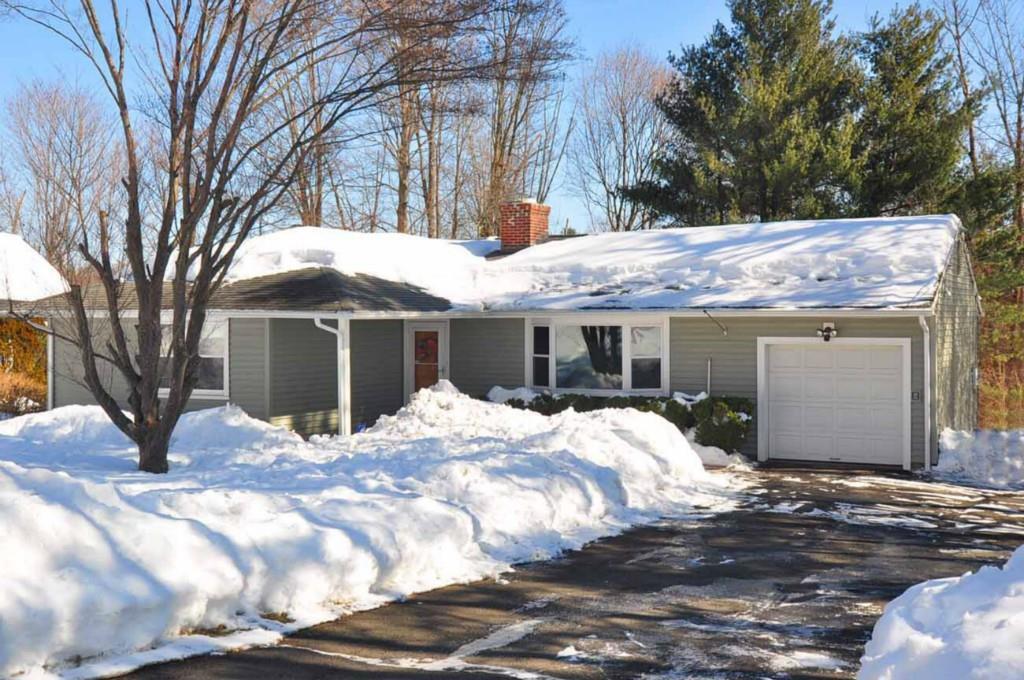 a view of a house with a yard covered in snow