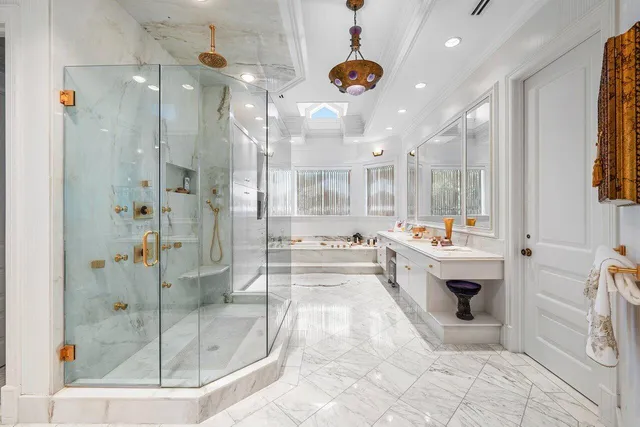 a bathroom with a sink double vanity and a glass door shower