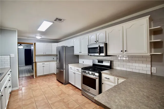 a kitchen with stainless steel appliances granite countertop a stove a sink and a refrigerator