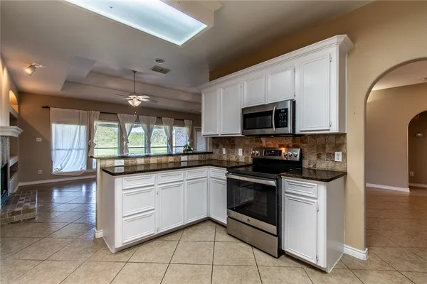 a kitchen with stainless steel appliances granite countertop a stove and a microwave