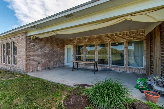a view of a house with a large window and wooden fence