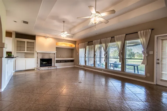 a view of an empty room with a fireplace and a window