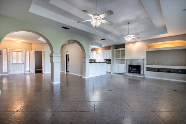 a view of empty room with a fireplace and a chandelier fan