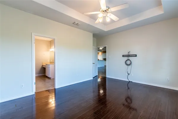 a view of empty room with wooden floor