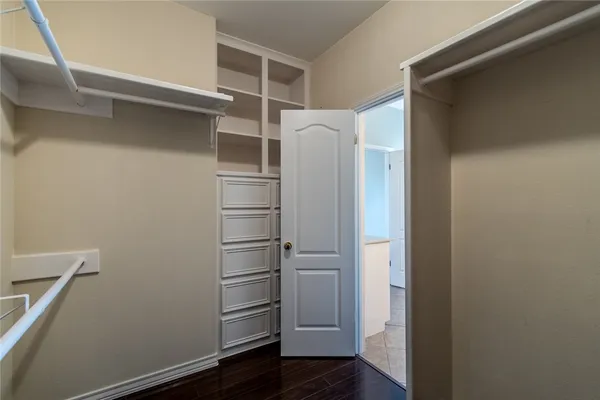 a view of walk in closet with empty racks