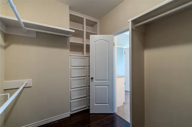 a view of walk in closet with empty racks
