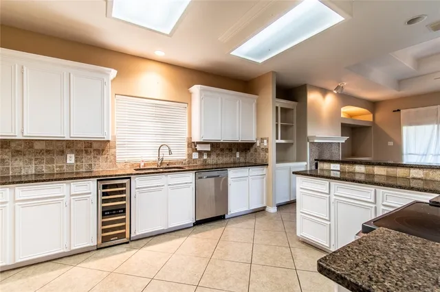a large kitchen with granite countertop a sink and cabinets