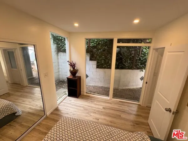 a view of a hallway with wooden floor and a living room