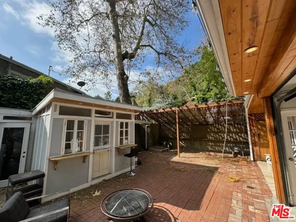 a backyard of a house with barbeque oven fire pit table and chairs