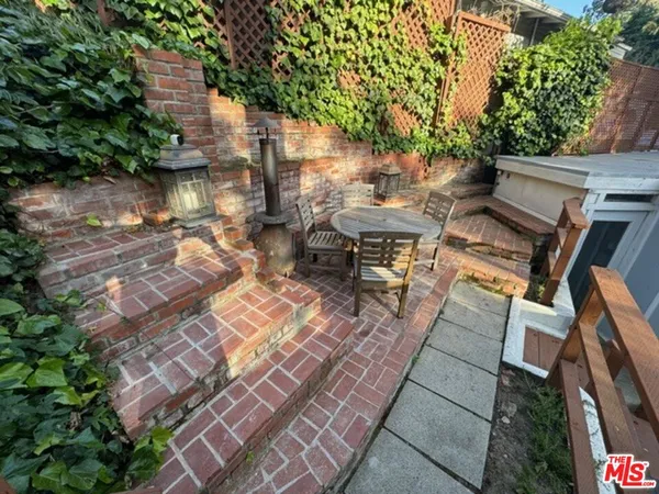 a view of a patio with table and chairs with wooden floor and fence
