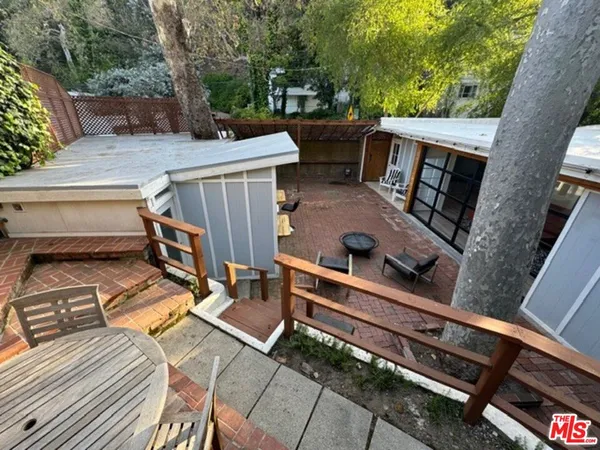 a view of a patio with table and chairs with wooden floor and fence