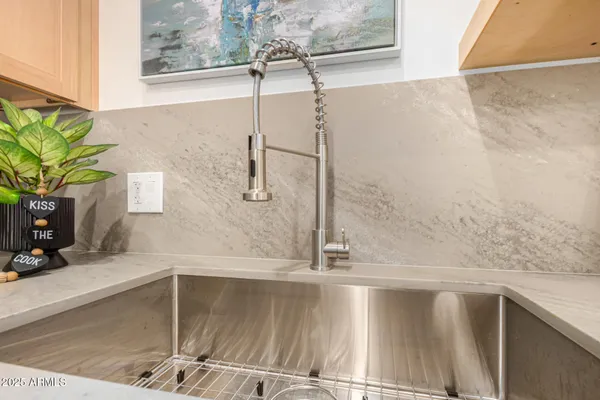 a kitchen with stainless steel appliances a stove a sink a refrigerator and white cabinets