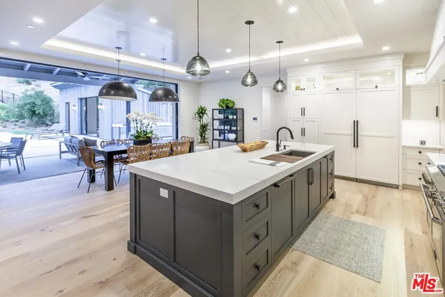 a kitchen with a stove a counter space a sink and a large window