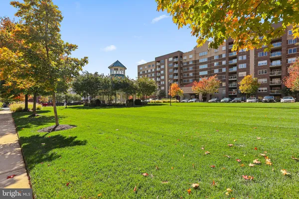 a view of a building in a big yard with large trees