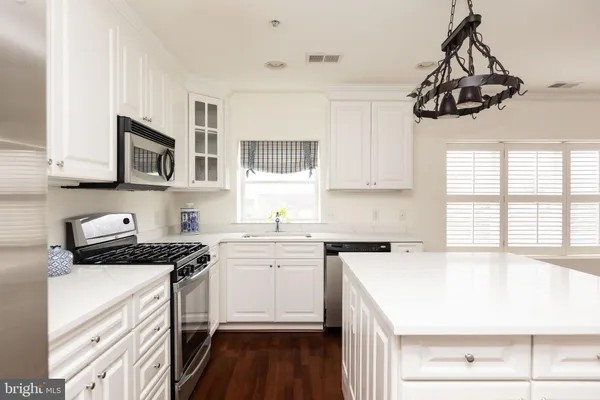 a kitchen with a sink a stove and cabinets