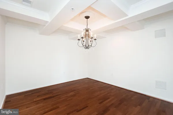 a view of a room with wooden floor and chandelier