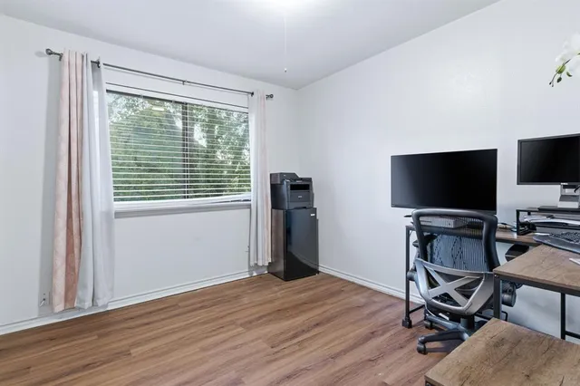 a view of a workspace with furniture and a window