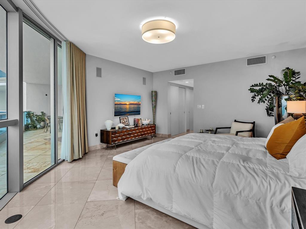 1600 South Ocean Boulevard, Unit 403 Pompano Beach, FL 33062 - Photo 12 of 52 a bedroom with bed and a chandelier