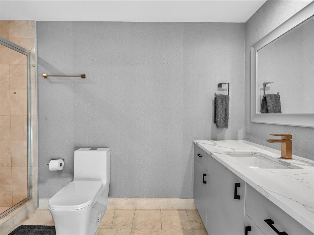 1600 South Ocean Boulevard, Unit 403 Pompano Beach, FL 33062 - Photo 22 of 52 a bathroom with a granite countertop sink a toilet and a mirror