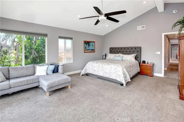 a bedroom with a large bed couch and a large window