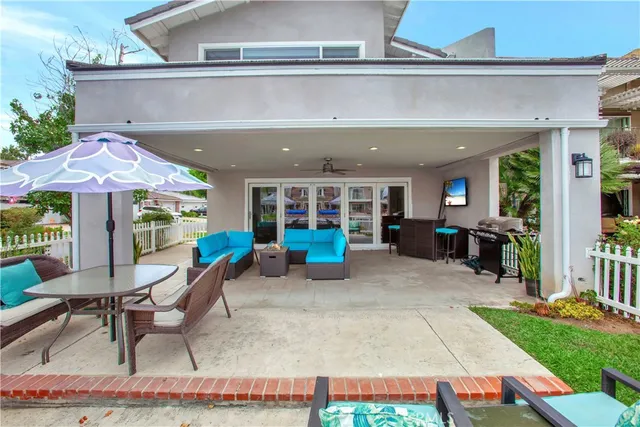 a backyard of a house with barbeque oven table and chairs