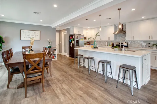 a dining area with stainless steel appliances kitchen island a table chairs and a kitchen view