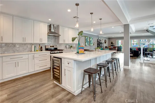 a kitchen with a sink a center island stainless steel appliances and cabinets