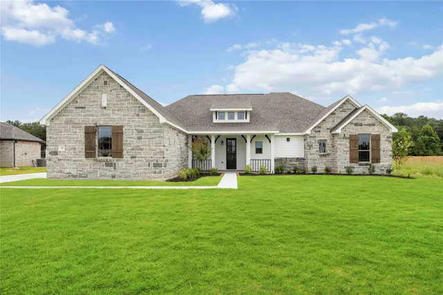 a front view of a house with a garden and yard