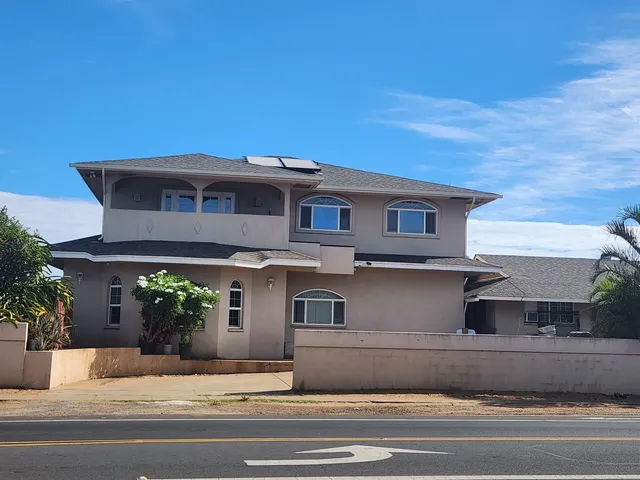 a front view of a house with a garden