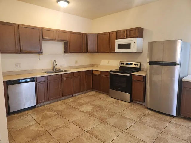 a kitchen with stainless steel appliances granite countertop a sink stove and refrigerator