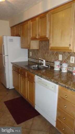 19517 Gunners Branch Road, Unit 432 Germantown, MD 20876 - Photo 2 of 6 a kitchen with stainless steel appliances granite countertop a stove a sink and a refrigerator
