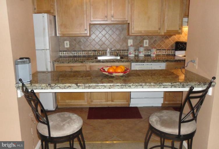 19517 Gunners Branch Road, Unit 432 Germantown, MD 20876 - Photo 3 of 6 a kitchen with a table chairs and a wooden cabinets